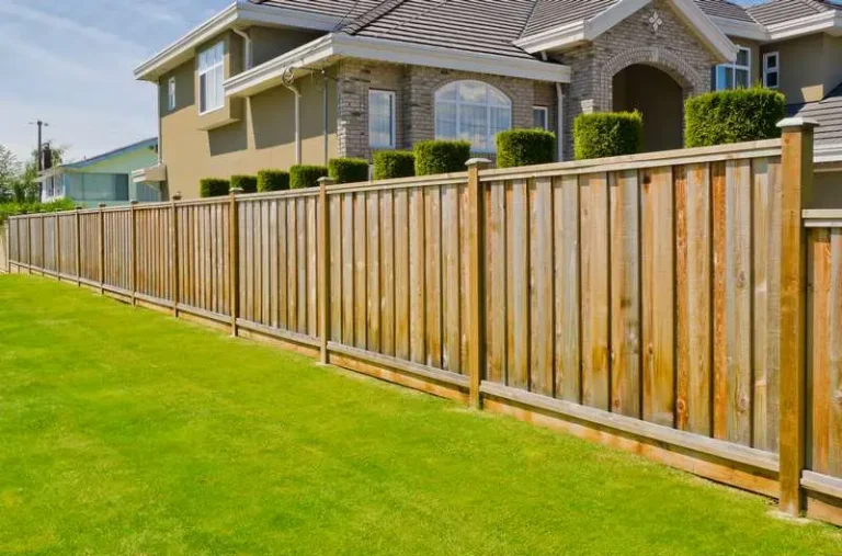 Wooden fence installation alongside a well-maintained lawn, enhancing property aesthetics and security for homes.